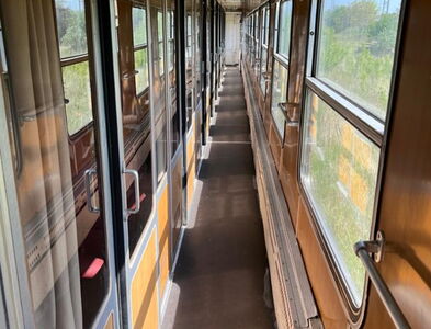 Blick in der Gang des Zuges mit allen Abteilen. Es ist ein schöner sonniger Reisetag.