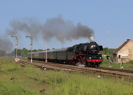 WFL Dampflokzug mit historischen Wagons fährt bei voller Fahrt und Dampf durch Landschaft